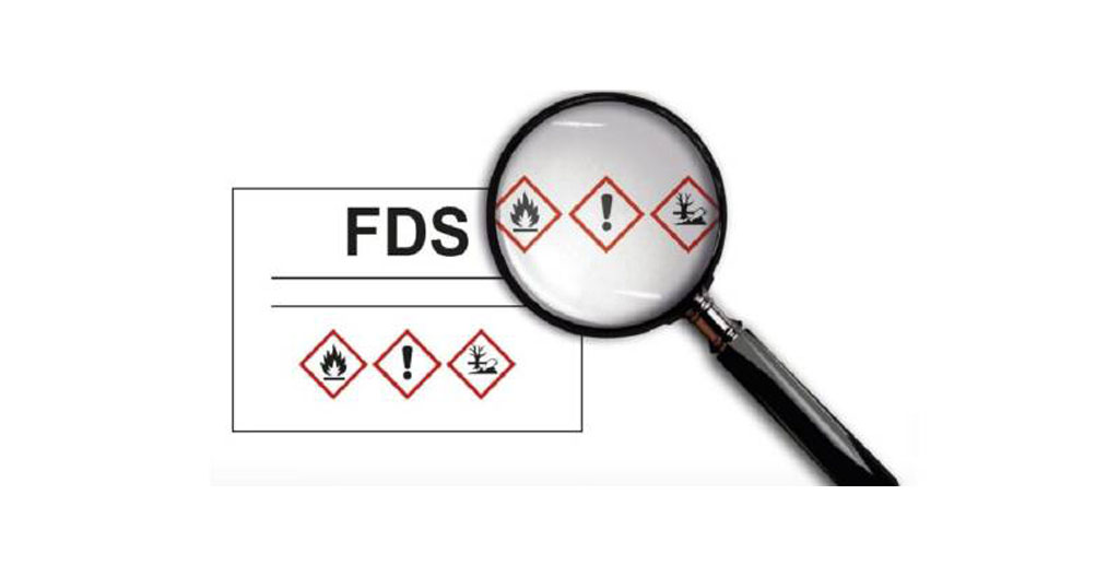 Fiche de Données de Sécurité (FDS) chimique officielle ouverte montrant les 16 rubriques normées et pictogrammes de danger CLP, posée sur un plan de travail professionnel avec stylo